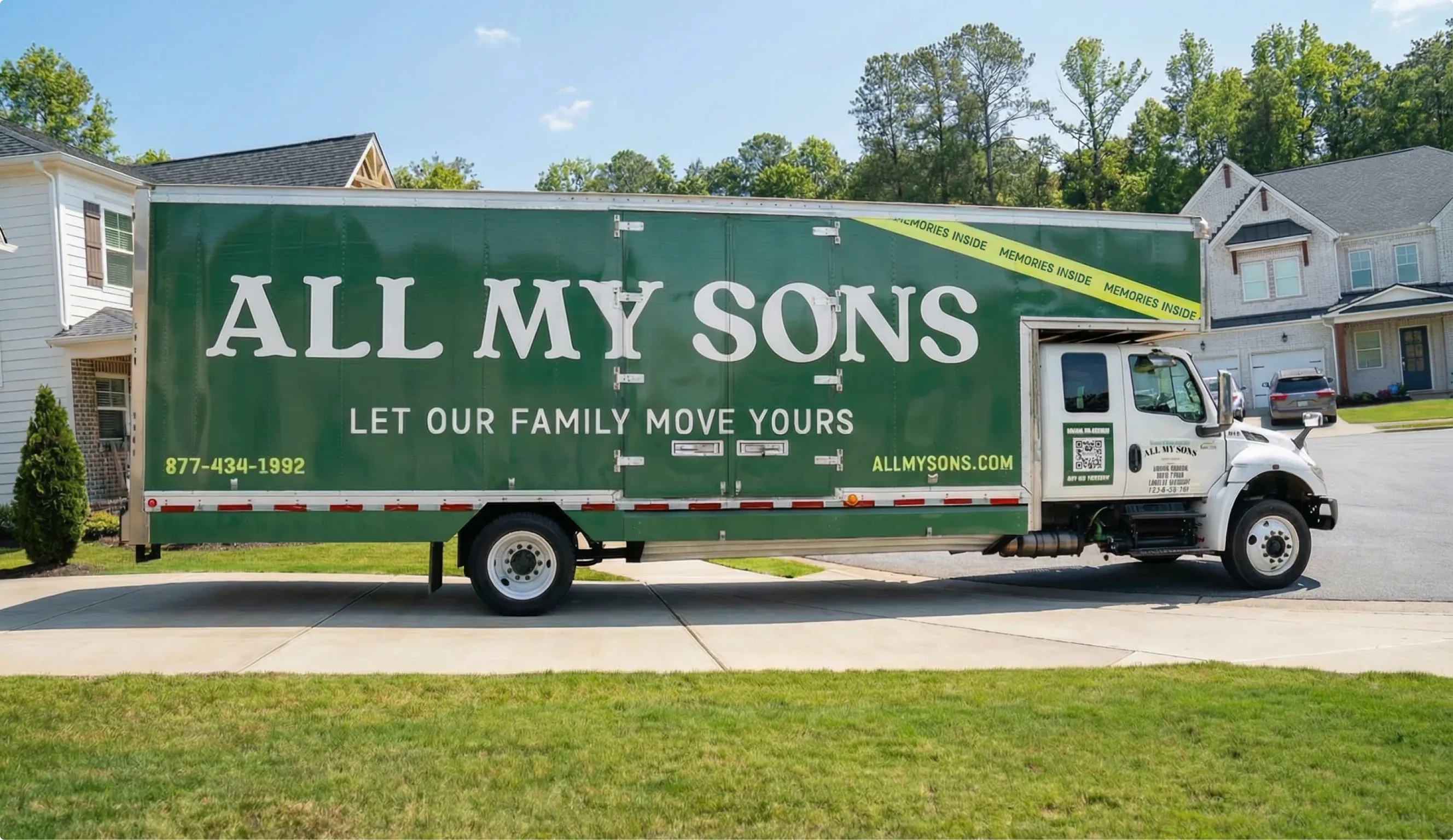 A green All My Sons truck reading “Let our family move yours” parked on a residential street.
