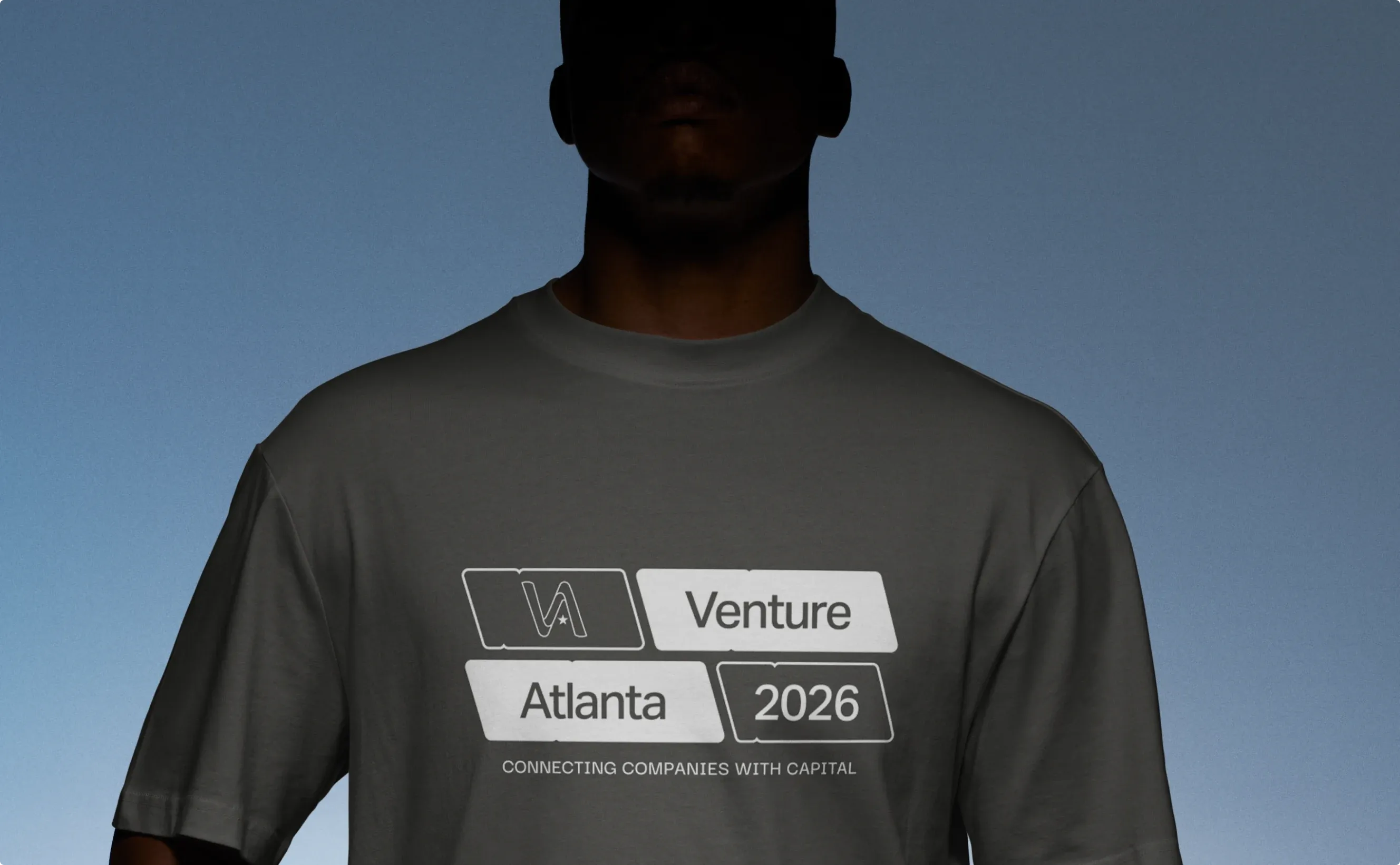 A man in a dark Venture Atlanta 2026 t-shirt, "Connecting companies with capital".