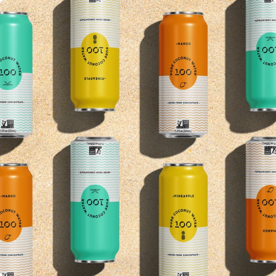 Rows of 100 Coconuts cans in every flavour on sand, seen from above.