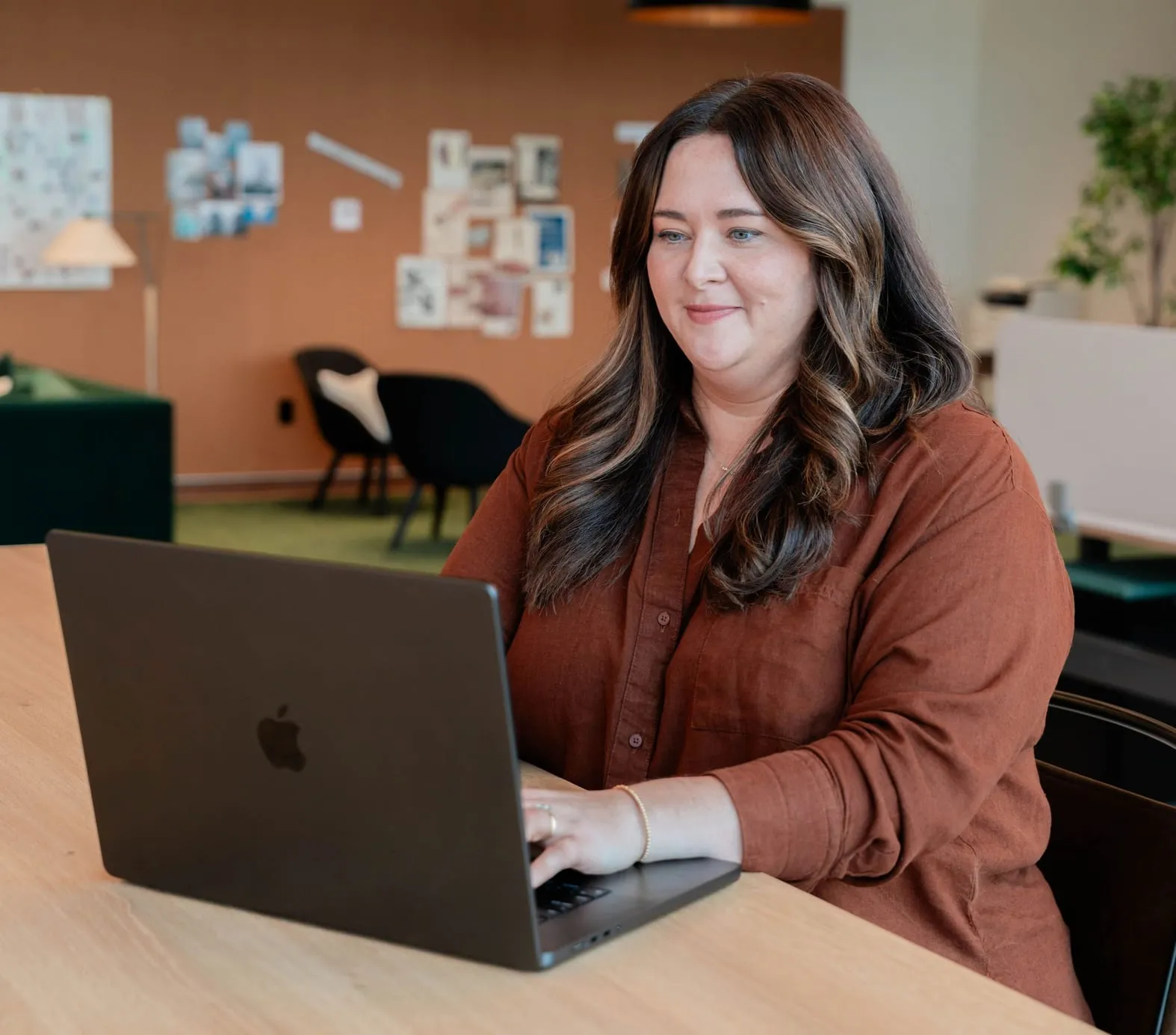 A colleague smiling as she works at her laptop