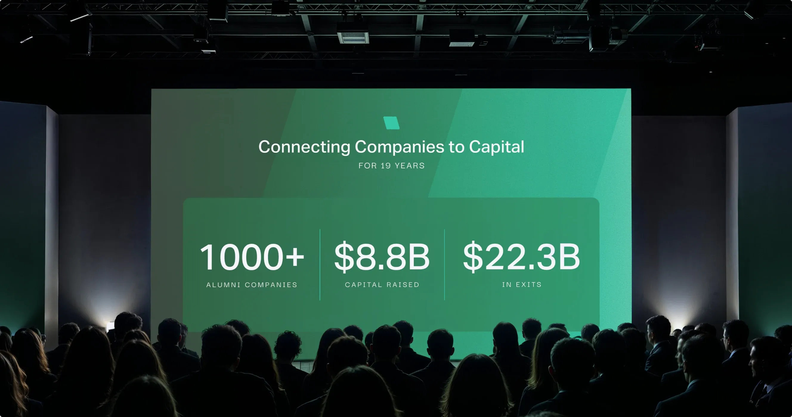 A packed hall facing the Venture Atlanta stage screen: "Connecting companies to capital for 19 years", 1000+ alumni companies, $8.8B capital raised, $22.3B in exits.